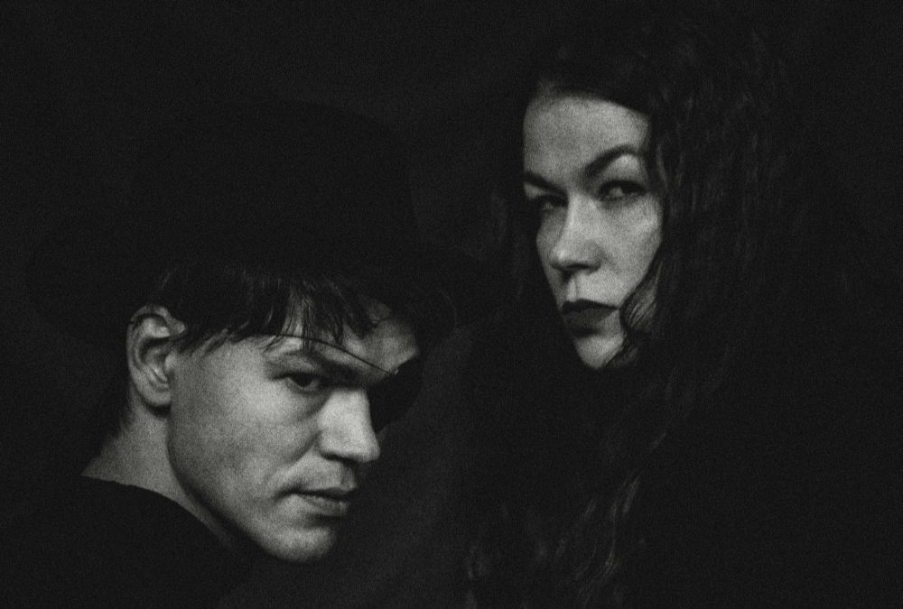 A man and woman looking over their shoulders in the darkness