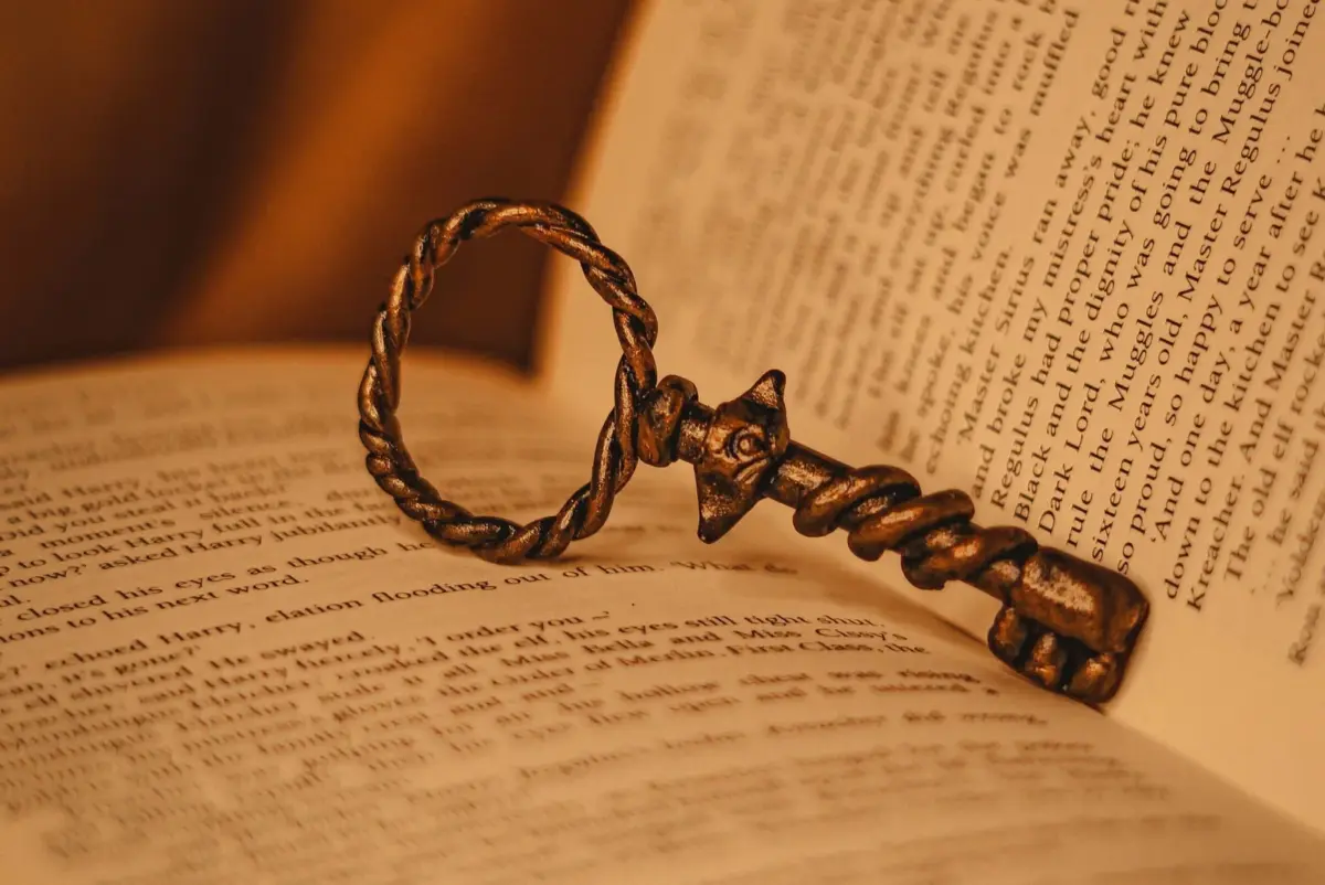 Old brass key lying between pages of a book