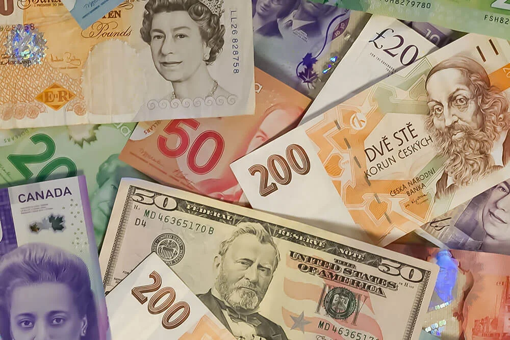 American, Czech, Canadian, and other foreign paper money lying in a pile