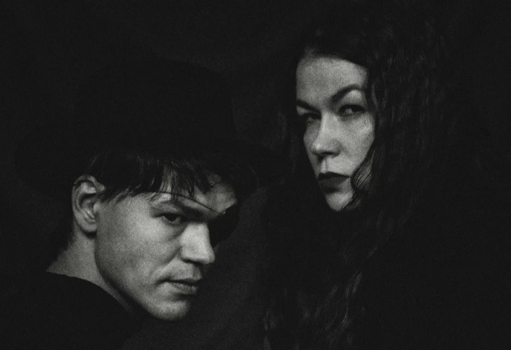 A man and woman looking over their shoulders in the darkness